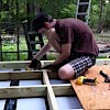 Fastening a blocking piece between two joists, with GRK R4 screws entering diagonally (toe-nailed).