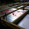 Four rigid foam sections in place; clamps holding bowed section tight to sheet metal underneath.