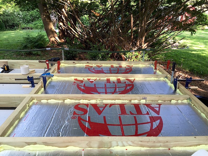 First layer of polyiso foam board going in, with clamps to hold pieces down while curing.