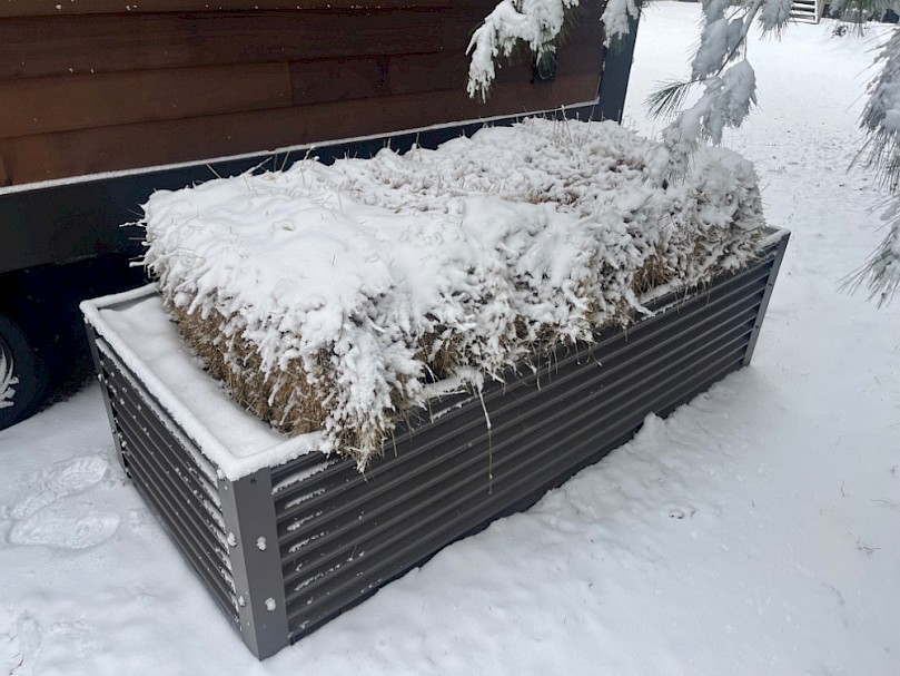 Greywater mulch basin in the winter with hay bales for insulation